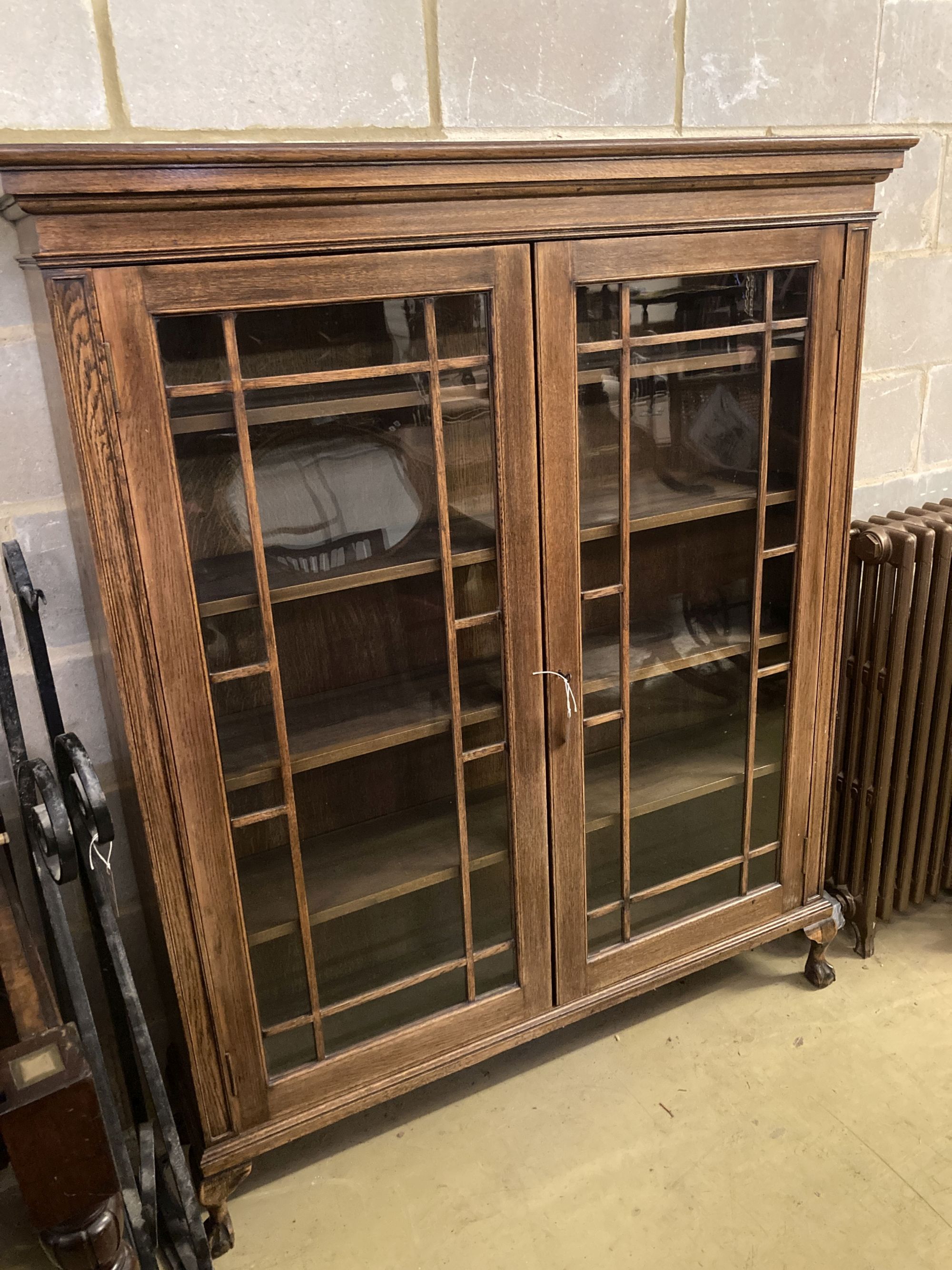 A 1920s glazed oak two door bookcase, length 130cm, depth 29cm, height 156cm